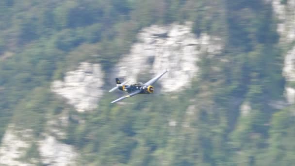 Historiska stridsflygplan under flygning i hög hastighet i en bergsdal — Stockvideo