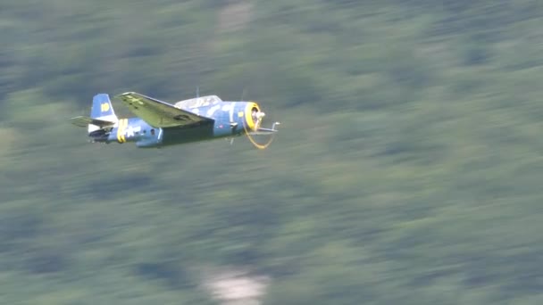 Hélice velho avião de combate em voo em alta velocidade perto de montanhas — Vídeo de Stock