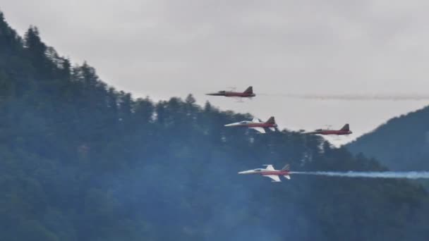 Формування реактивних літаків швидко летить у вузькій долині з білим димом. — стокове відео