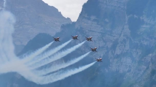 Военный самолет проходит под строем стрел из 5 струй с белым дымом — стоковое видео
