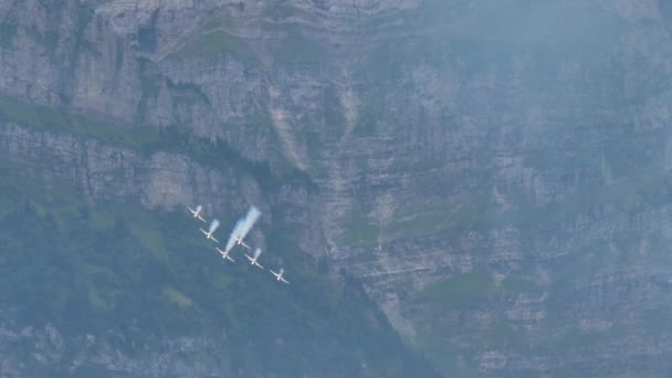 Caça jatos voar em formação em um vale verde estreito com trilhas brancas — Vídeo de Stock