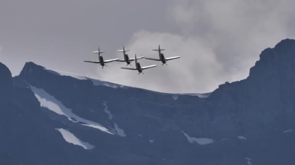 Čtyři aerobati letadla udělat smyčku v diamantové formaci s horami jako pozadí — Stock video