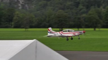 Pilatus PC-9M çift koltuklu kırmızı ve beyaz turbo pervaneli uçak kalkıyor.