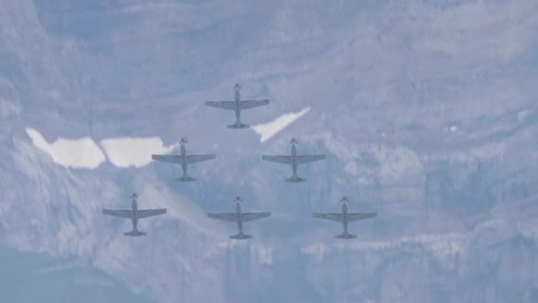 Bildande av sex militära propellerflygplan slingor genom bergen — Stockvideo