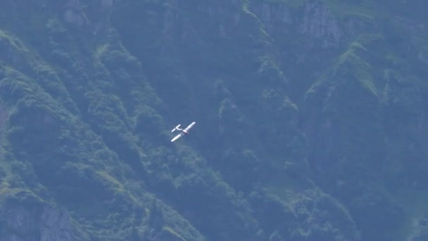 Propellerflugzeug aus dem Zweiten Weltkrieg fliegt in einem grünen Gebirgstal — Stockvideo