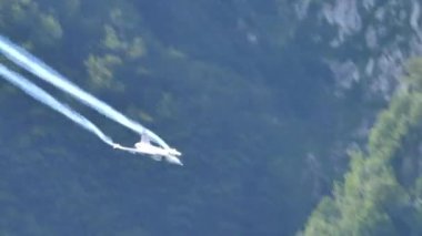 Savaş uçağı yüksek hızda ve alçak irtifada dar yeşil bir vadide uçuyor.