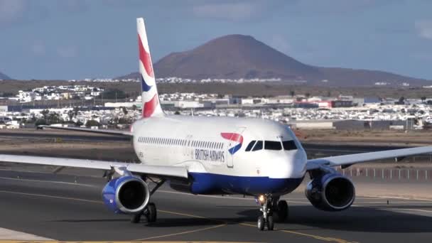 Primer plano de un avión que circula en la pista con paisaje volcánico — Vídeos de Stock