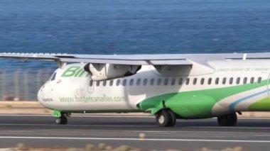 Küçük pervaneli yolcu uçağı arka plan olarak okyanusla birlikte havalanır.