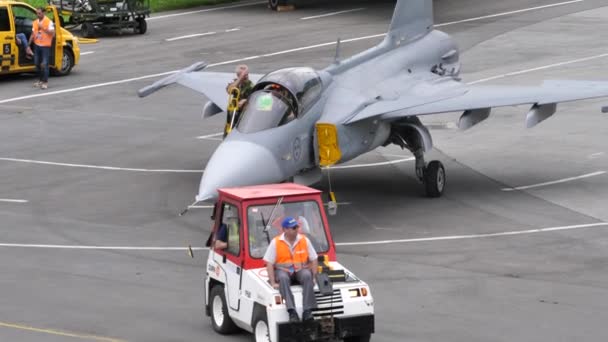 Mechanica slepen een militair gevechtsvliegtuig naar de parkeerplaats met een trekker — Stockvideo