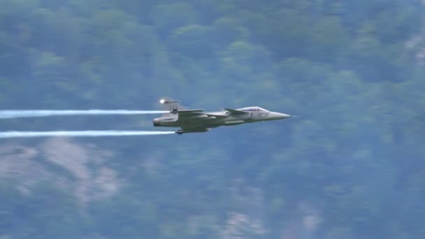 Slow motion closeup of a supersonic fighter jet in flight with white smoke trail — Stock Video