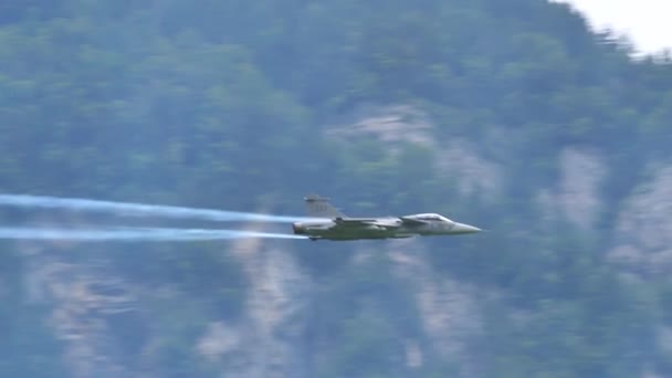 Відео повільного руху реактивного літака винищувача робить рол з білими стежками. — стокове відео
