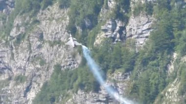 Savaş uçağı bir hava gösterisi sırasında dağa yakın bir yerde yüksek hızda tırmanır.