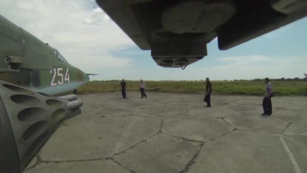 Mekaniken får ett militärt stridsflygplan som stannar vid parkering efter en flygning — Stockvideo