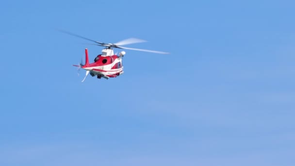 Helikopter Agusta A109E vliegt in de blauwe lucht. Reddingsdemonstratie — Stockvideo