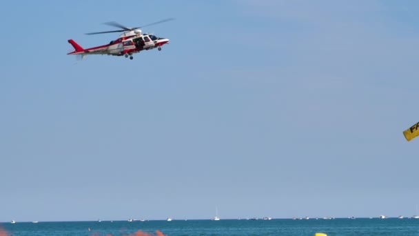 Brandmän i sjöräddningsövningen. Helikopter Agusta A109 svävar över havet — Stockvideo