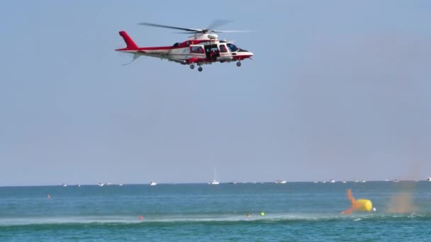Equipa de bombeiros a fazer exercício de salvamento marítimo. Helicóptero flutuando acima do mar — Vídeo de Stock