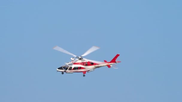 Serviço de resgate marítimo, Helicóptero AugustaWestland AW109 voa sobre o céu limpo — Vídeo de Stock