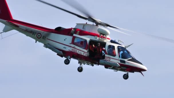 Brandmän i sjöräddningsövningen. Helikopter Agusta A109E som flyger över havet — Stockvideo