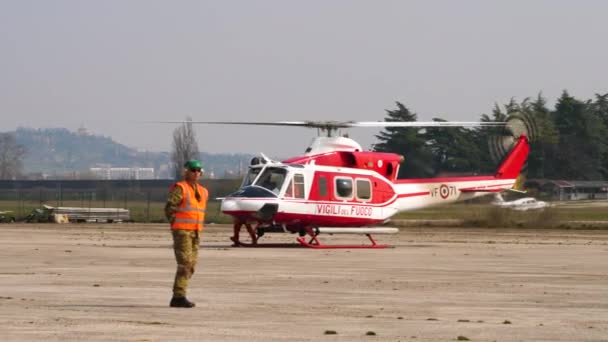 Військові сили охороняють вертоліт Agusta Bell AB-412 під час буріння пожежників — стокове відео