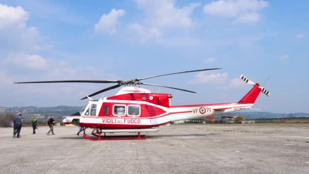Mensen passeren geparkeerde helikopter. SATER, training van brandweerlieden — Stockvideo