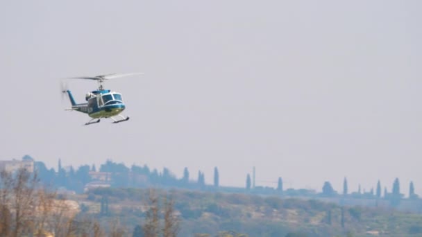 Der Polizeihubschrauber Agusta Bell AB-212 fliegt über die Bäume. Such- und Rettungseinsatz — Stockvideo
