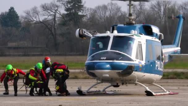 Rescuers in rescue presentation preparing equipment in front of the helicopter — Stock Video