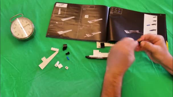 Volwassen persoon bouwen 10283 NASA Space Shuttle Discovery en timing van het proces — Stockvideo