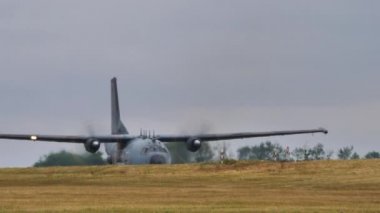 C-160 'ı çevir. Pistte taksicilik yapan askeri uçağın uzaktan görüntüsü.