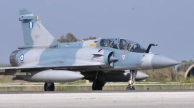 İki koltuklu modern askeri jet ve kalkışı bekleyen Yunanistan bayrağı