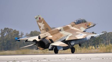 Çöldeki savaş uçağı kahverengi kamuflaj ile arkadan iniş yapıyor.