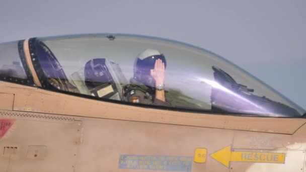 Vista cercana de un piloto militar en la cabina de un avión de combate saludo — Vídeo de stock