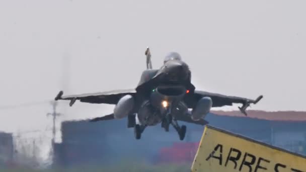 Vista frontal de cerca de un avión de combate gris de la OTAN aterrizaje con neumáticos humeantes — Vídeos de Stock