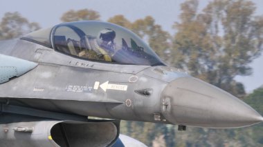 NATO gri savaş uçağının kokpitinde miğferi olan askeri pilot.