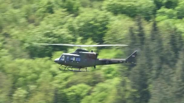 Närbild, Agusta Bell 412 flyger nära kullarna med skog. Sloveniens sök- och räddningsdemonstration för flygvapnet — Stockvideo