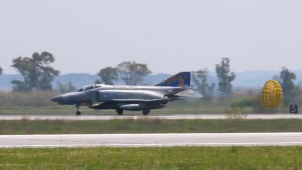 Wojskowy samolot myśliwski ląduje z otwartym spadochronem hamulcowym w ogonie — Wideo stockowe