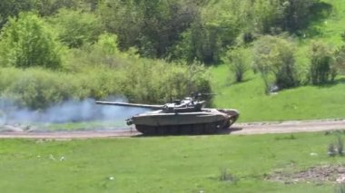 Soğuk savaş zamanı Sovyet T-72 tankı tepenin üstünde giderken ardında duman bırakıyor. Atışı izle