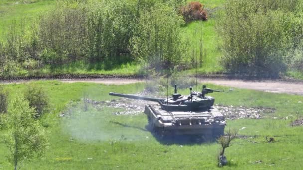 Militaire voertuig Sovjet T-72 gevechtstank verlaten rook geparkeerd op groen veld — Stockvideo