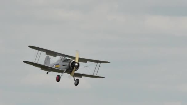 Britisches Doppeldecker-Propellerflugzeug der 1930er Jahre landet auf Grasflugplatz — Stockvideo