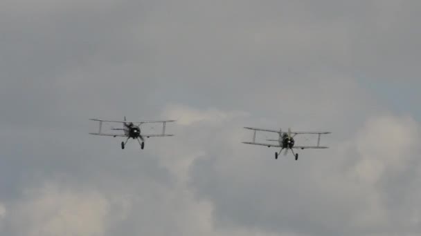 Pair of 1930s fighter biplanes in flight during a historical reenactment — Stock Video