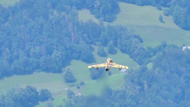 Samolot szybko wznosi się do nieba z zielonym lasem alpejskim w tle — Wideo stockowe