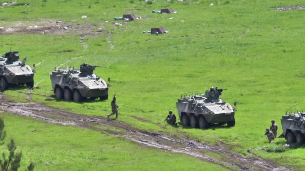 Солдати біжать до припаркованих танків під час військової демонстрації на полігоні. — стокове відео