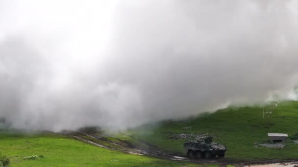 Ağır dumanlı askeri zırhlı taşıyıcı araçlar yükseliyor. — Stok video