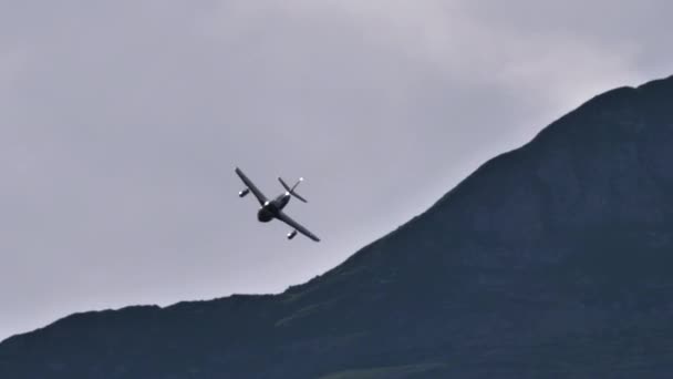 1950s single-engine jet warplane in low and fast flight in an alpine valley — Stock Video