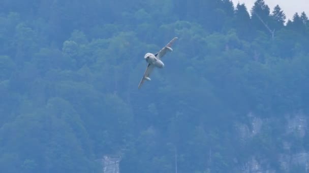 Vista ravvicinata di un aereo militare a reazione che vola ad alta velocità in una valle — Video Stock