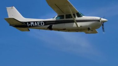 Az bulutlu, mavi güneşli gökyüzünde uçan klasik Cessna uçakları