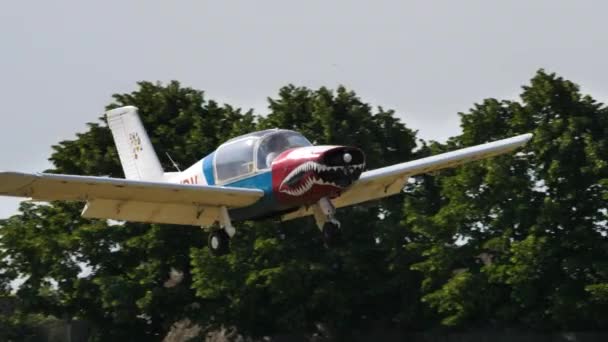 Klein propellervliegtuig lage snelheid passeren met flappen uit op de baan van een klein vliegveld — Stockvideo