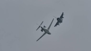 Askeri savaş uçağı, uçarken lüks bir özel uçağın yolunu kesiyor.