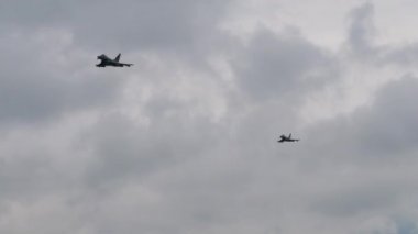 Savaş uçakları bulutlu havada alçak irtifada köpek dövüşü yapar.
