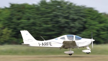 Ultralight uçağı güneşli bir yaz gününde kırsal bir havaalanına iniyor.