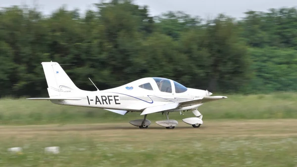 Avión ultraligero aterrizando en una pista de aterrizaje rural en un día soleado de verano — Foto de Stock